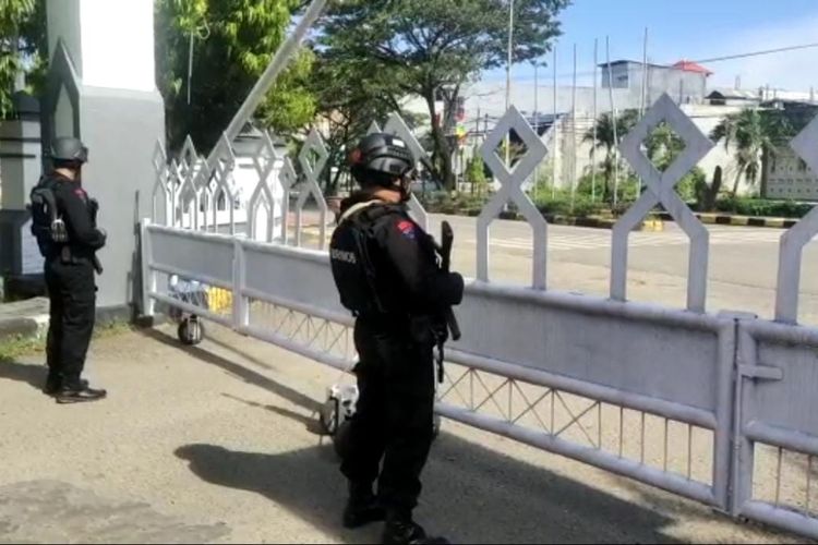 Polisi bersenjata lengkap berjaga di pintu masuk Kantor Bupati Pinrang, Sulawesi Selatan, Selasa (6/4/2021). Penjagaan ketat berlangsung setelah ada penemuan kotak hitam mencurigakan di halaman kantor tersebut.