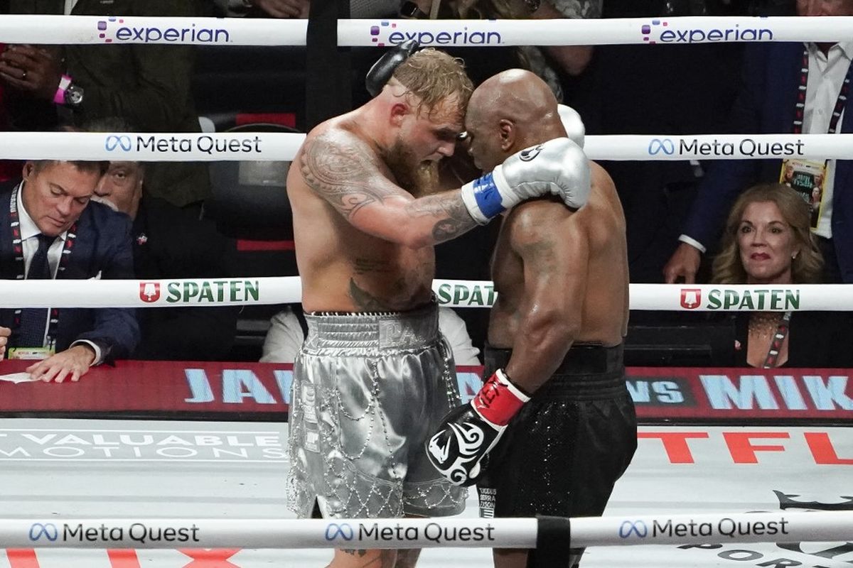 Mike Tyson (kanan) berpelukan dengan sang lawan Jake Paul yang mengalahkannya dalam pertarungan tinju kelas berat di The Pavilion Stadion AT&T, Arlington, Texas, 15 November 2024. (Photo by TIMOTHY A. CLARY / AFP)