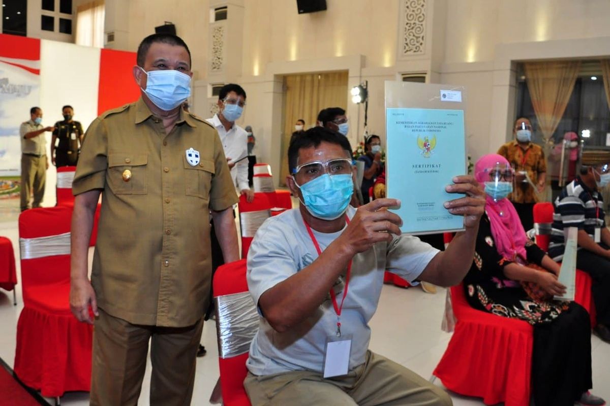 Seorang warga Gorontalo memperlihatkan sertifikat tanah yang baru dimilikinya di samping Wakil Gubernur Idris Rahim.