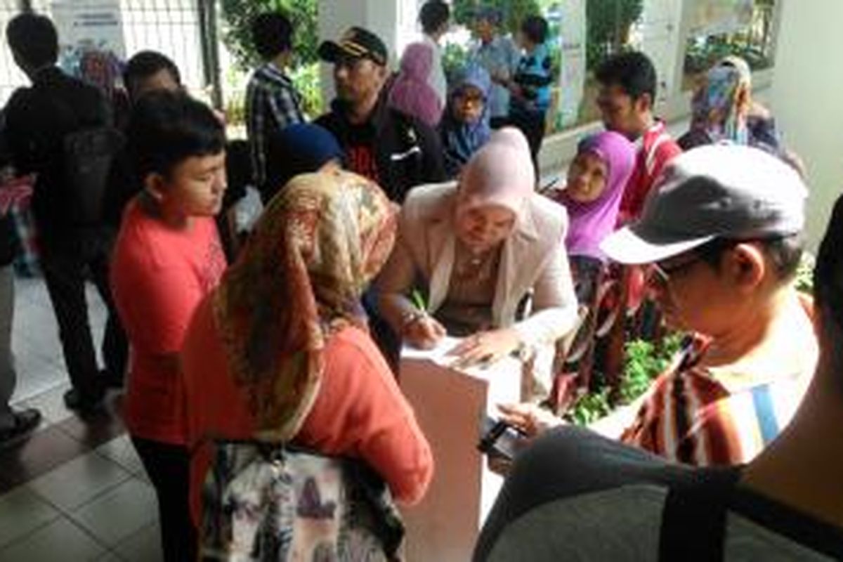 Keluarga korban kebakaran, menandatangani kwitansi tunjangan transport sebesar Rp 1 juta yang diberikan PT Mandom di depan gedung Unit Luka Bakar RSCM, Jakarta pusat, Minggu (12/7/2015).