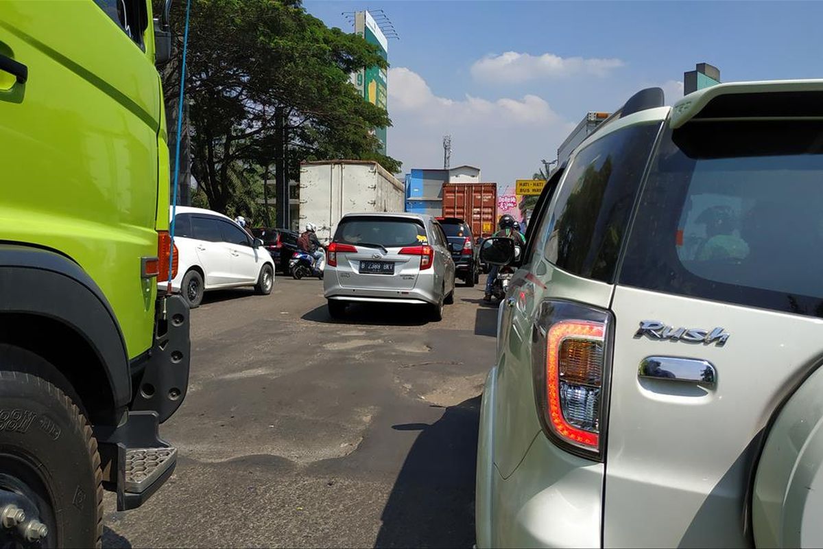 Jalanan berlubang di jalan raya menuju Bundaran Tarian Langit Kota Harapan Indah, Bekasi, Jawa Barat.