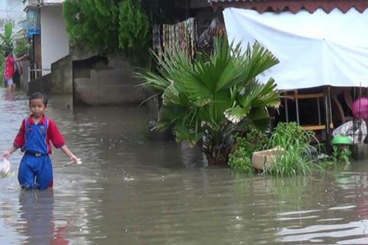 Seorang bocah berjalan di tengah genangan bajir di Kelurahan Gedung Nasional Pangkalpinang Kepulauan Bangka belitung