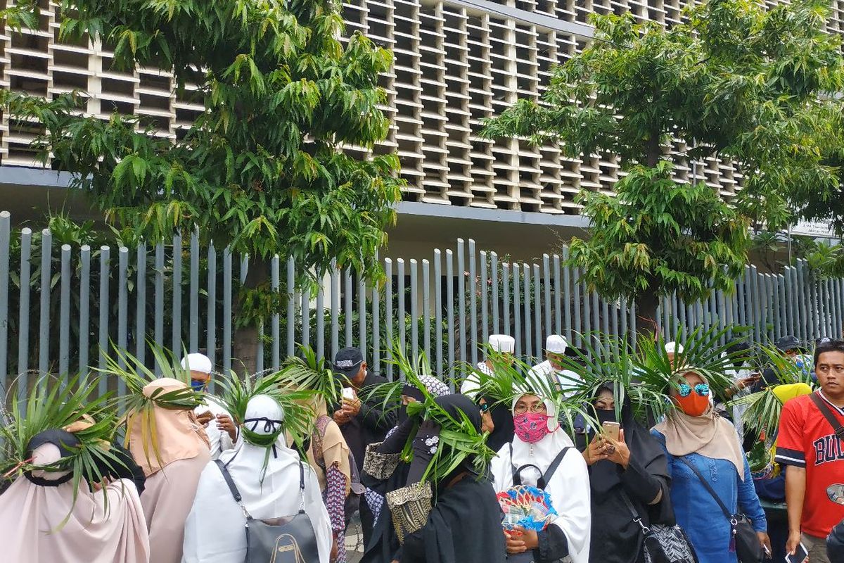 Sejumlah perempuan paruh baya mengenakan ikat kepala dari daun palem sebagai simbol aksi damai di Bawaslu pada Jumat (10/5/2019) siang.