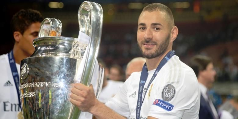 Penyerang Real Madrid, Karim Benzema, berpose dengan trofi seusai El Real menjuarai Liga Champions, Sabtu (28/5/2016). 