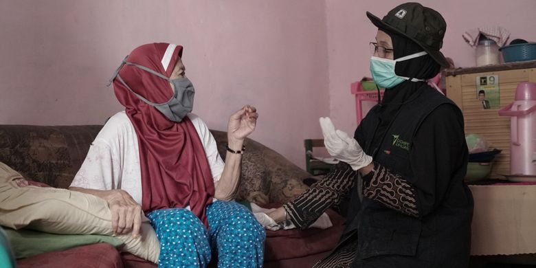 Petugas medis Dompet Dhuafa sedang memeriksa kesehatan seorang wanita lansia dalam layanan Mobile Health Service. 