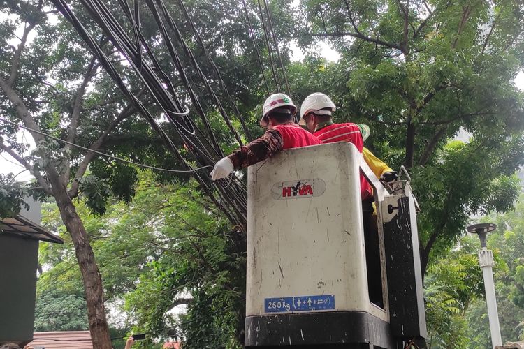 Wali Kota Jakarta Selatan Munjirin saat memotong kabel fiber optik di Jalan Senopati, Kebayoran Baru, Jakarta Selatan, Kamis (23/11/2023).