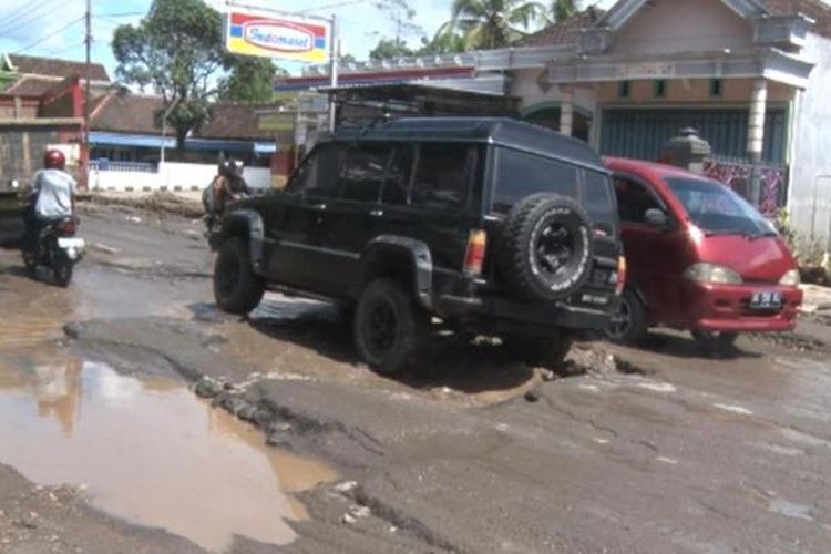 Kendaraan melintas di jalan berlubang di Desa Ngetal, Kecamatan Pogalan, Kabupaten Trengalek, Jawa Timur, Kamis (23/2/2017).