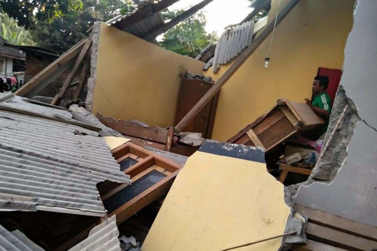 Warga di sekitar reruntuhan bangunan rumah yang rubuh akibat gempa di Lombok, NTB, Minggu (29/7/2018). Berdasarkan informasi dari Badan Meteorologi Klimatologi dan Geofisika (BMKG) gempa pertama kali mengguncang Lombok Timur dengan kekuatan 6,4 skala Richter (SR) pada pukul 06.47 Wita.