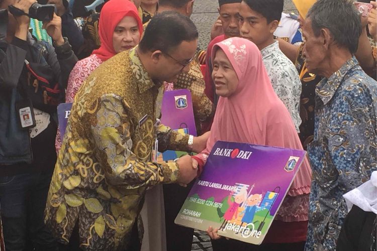 Gubernur DKi Jakarta Anies Baswedan membagikan secara simbolis Kartu Lansia Jakarta kepada sejumlah lansia di Halaman Monumen Nasional (Monas), Kamis (21/12/2017)