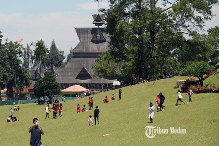 Sejumlah pengunjung menikmati suasana padang rumput hijau di Bukit Kubu, Brastagi, Sumatera Utara, Minggu (5/8/2019) 