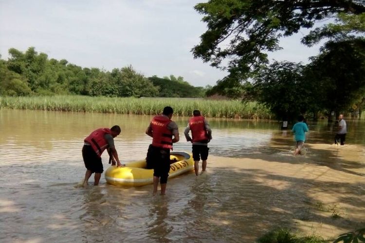 Anggota kepolisian melakukan patroli pengamanan titik jalan raya yang terdampak banjir di wilayah Kecamatan Kwadungan, Kabupaten Ngawi, Senin (24/4/2017) pagi.