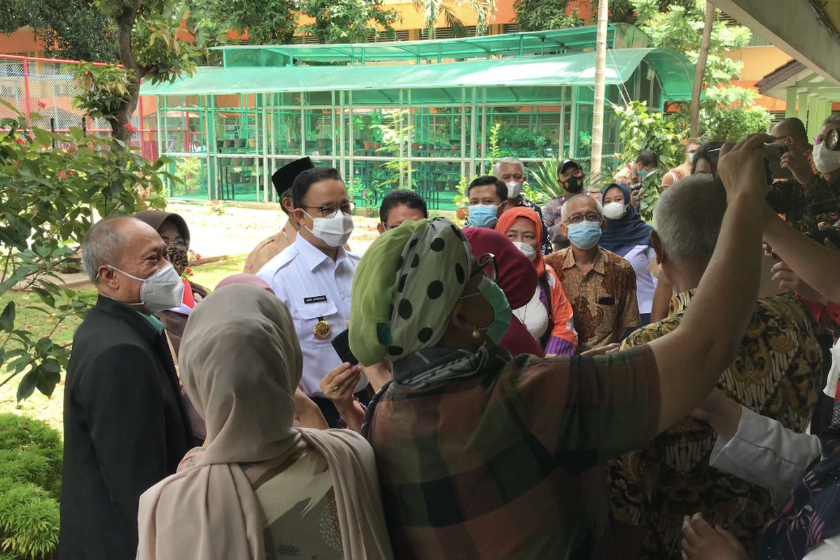 Kehadiran Gubernur DKI Jakarta Anies Baswedan ke lokasi vaksinasi Covid-19 menarik perhatian para perwakilan guru, tenaga pendidikan, dan dosen dari wilayah Jakarta dan sekitarnya di SMAN 70, Kebayoran Baru, Jakarta Selatan pada Rabu (24/2/2021).