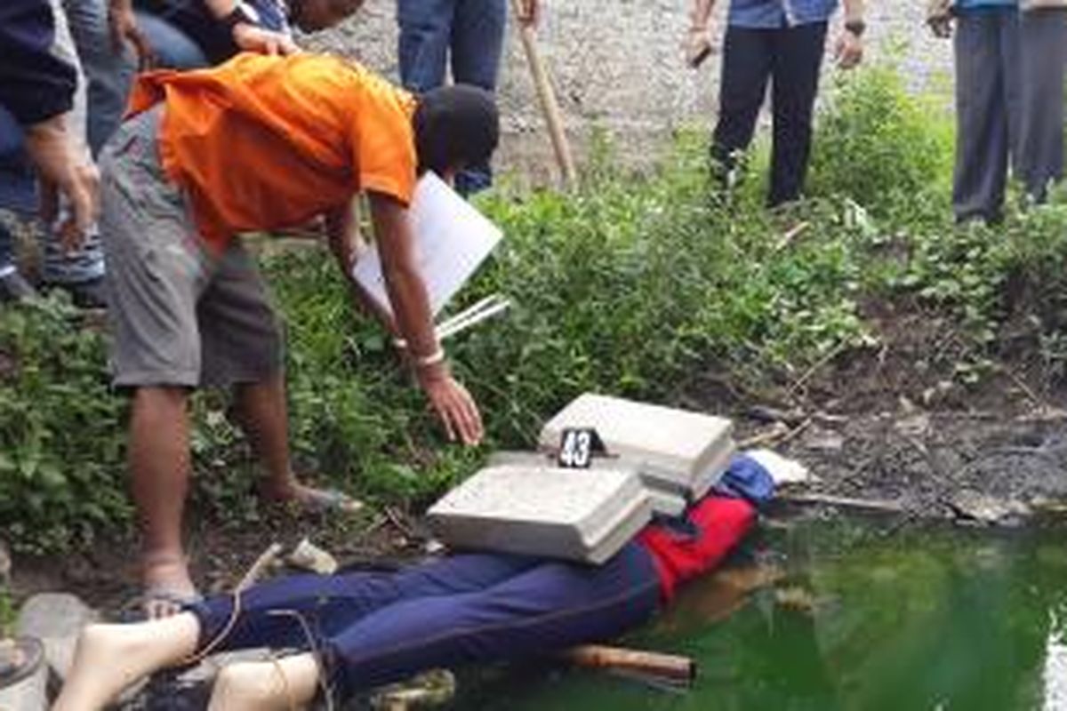 Bahrul Ulum (26) sedang menaruh batu di punggung Musyarafah di empang Balaraja, Kabupaten Tangerang. Bahrul berusaha menghilangkan jejak Musyarafah yang dibunuhnya pada 31 Mei 2015 lalu.