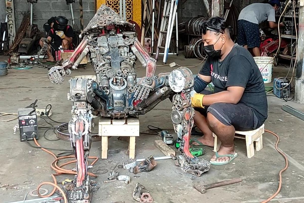 Seorang pekerja sedang membuat repliak robot dari motor bekas di Er Studio Art Yogyakarta