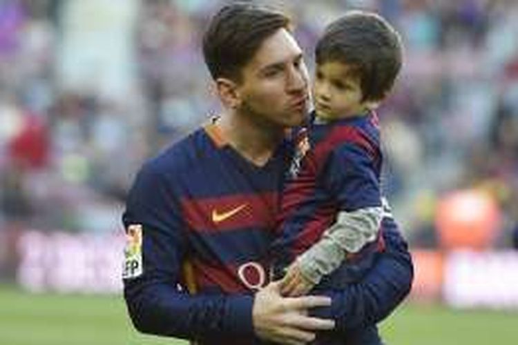 Pemain FC Barcelona, Lionel Messi, menggendong anaknya, Thiago, menjelang laga kontra Real Sociedad di Stadion Camp Nou, pada 28 November 2015.