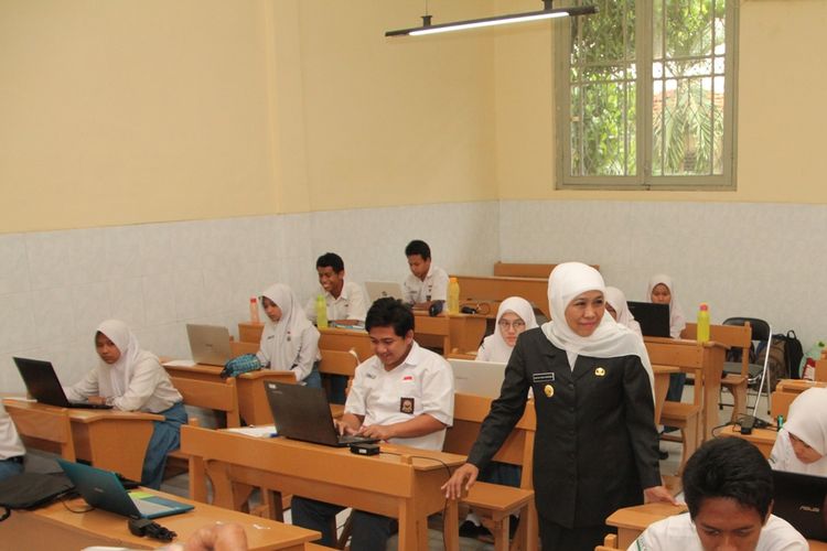 Gubernur Jawa Timur Khofifah Indarparawansa di antara siswa-siswi SMA.