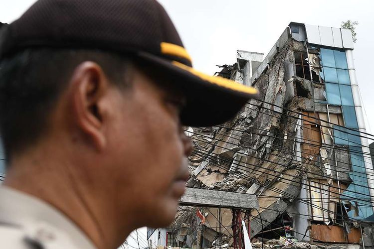 Polisi mengamati bangunan yang ambruk di Jalan Brigjen Katamso, Kota Bambu Selatan, Palmerah, Jakarta Barat, Senin (6/1/2020). Sebanyak 11 orang menjadi korban dari ambruknya bangunan empat lantai yang penyebabnya masih terus diselidiki ini.
