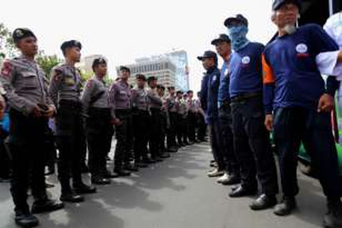 Anggota polisi berjaga saat aksi unjuk rasa di depan PN Jakarta Utara, Selasa (20/12/2016). Gubernur non-aktif DKI Jakarta Basuki Tjahaja Purnama akhirnya menjalani sidang sebagai terdakwa kasus dugaan penodaan agama.