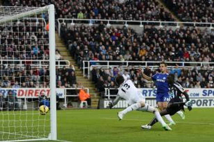 Striker Newcastle United, Papiss Cisse, saat melakukan tendangan yang berujung gol ke gawang Chelsea pada lanjutan Premier League di St James Park, Sabtu (6/12/2014). 