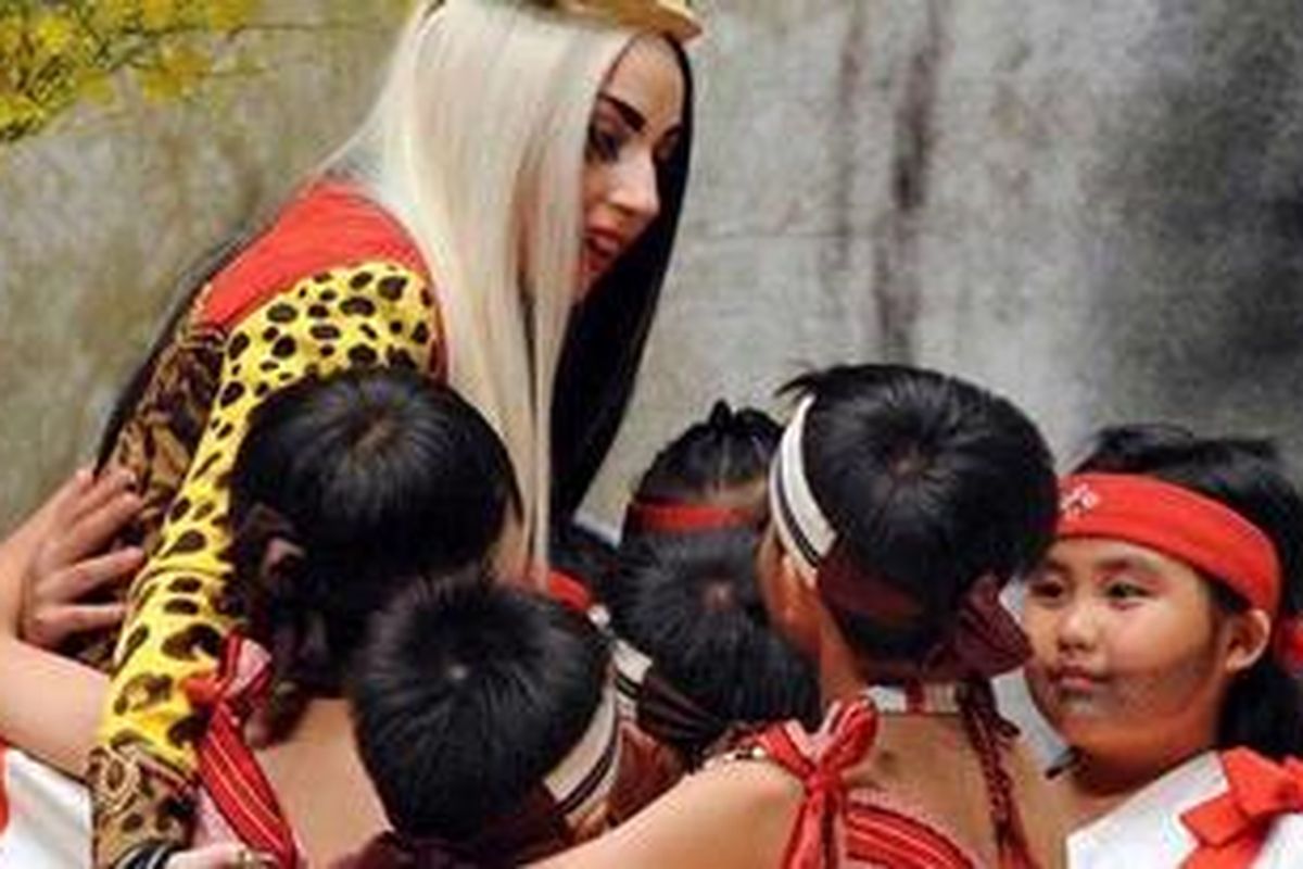 Lady Gaga dikelilingi oleh anak-anak suku bangsa Tai Ya, dari bagian timur Taiwan, ketika ia mengunjungi Taichung, 3 Juli 2011. 