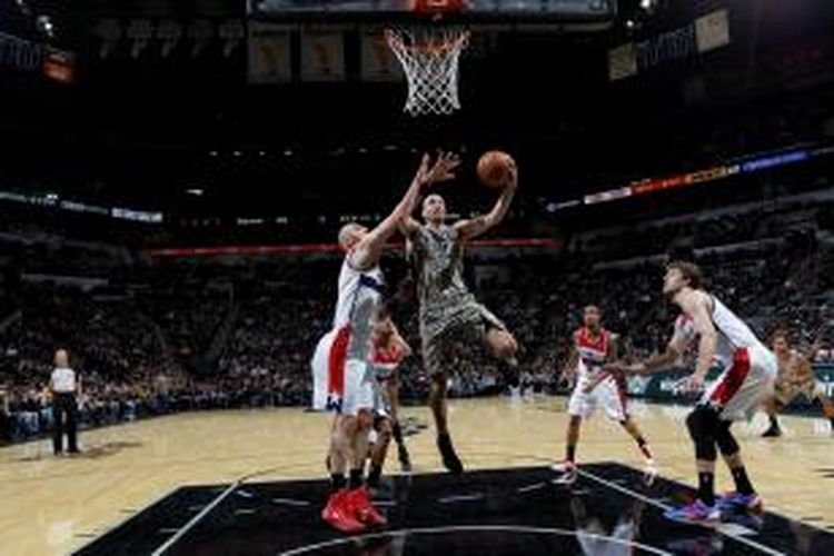 Pebasket San Antonio Spurs, Manu Ginobili (20) mencoba memasukkan bola di tengah kerumunan pemain Washington Wizards, pada lanjutan kompetisi NBA, Rabu (13/11/2013).