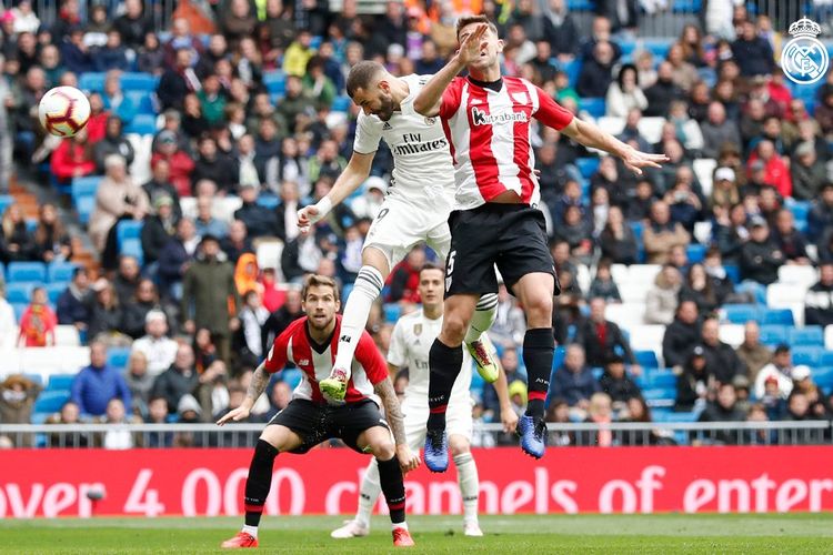 Striker Real Madrid, Karim Benzema (tengah), menyundul bola untuk menjebol gawang Athletic Bilbao dalam pertandingan Liga Spanyol di Santiago Bernabeu, Minggu (21/4/2019).