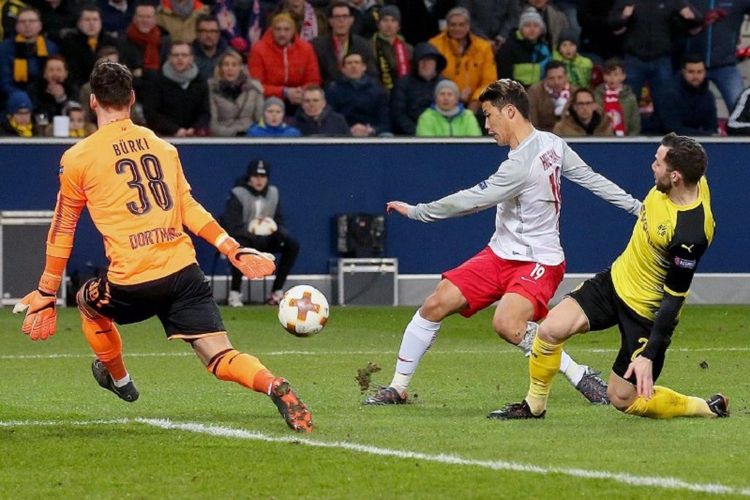 Penyerang Salzburg asal Korea Selatan, Hwang Hee-chan, masih sempat melepas tendangan ke arah gawang Borussia Dortmund yang dijaga Roman Buerki kendati dapat pengawalan dari Gonzalo Castro pada laga babak 16 besar Liga Europa, Kamis (16/3/2018). 