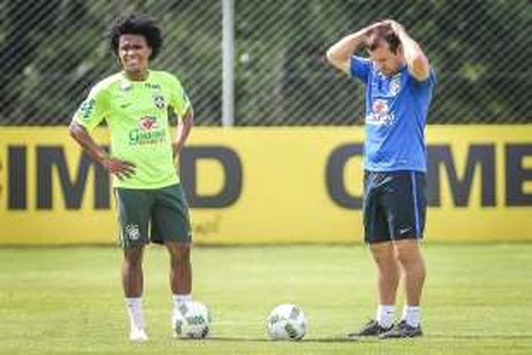 Pelatih tim nasional Brasil, Carlos Dunga (kanan), berbincang dengan salah satu gelandangnya, Willian, pada sesi latihan di Viamao, Brasil, 28 Maret 2016.