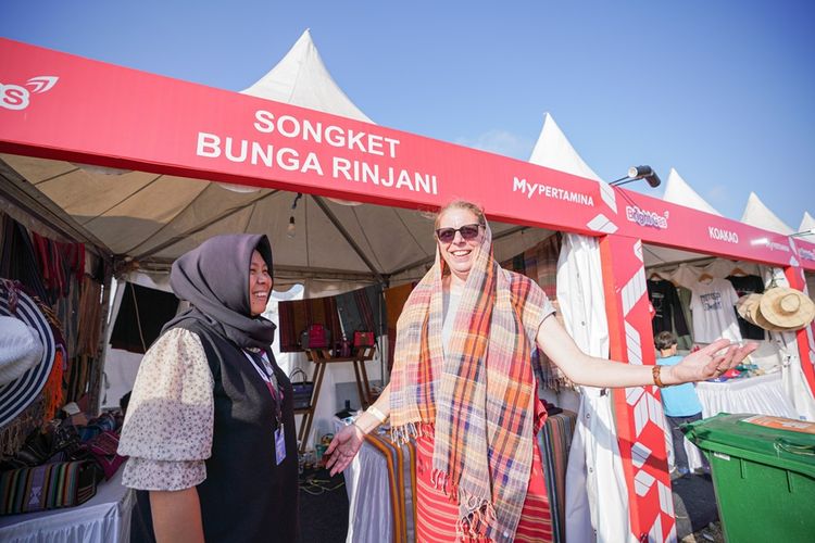 Seorang wisatawan mengenakan songket khas Lombok hasil karya salah satu mitra UMKM binaan Pertamina dalam acara Pertamina Grand Prix of Indonesia.