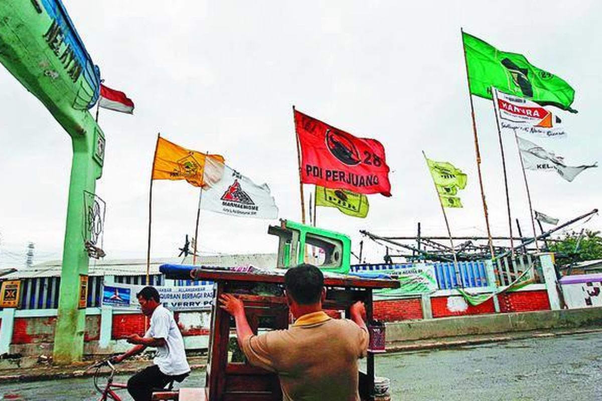 Bendera partai politik menghiasi sekitar gerbang masuk ke permukiman nelayan di kawasan Muara Angke, Jakarta Utara, seperti terlihat Sabtu (20/12). Menjelang Pemilu 2009, parpol dan calon anggota legislatif berlomba menarik simpati rakyat melalui berbagai atribut kampanye, termasuk bendera.  