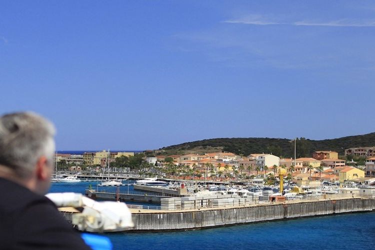 Orang-orang berdiri di dek kapal feri baru Mega Andrea dari perusahaan French Corsica Ferries, pada 31 Mei 2016 saat mereka melihat ke pelabuhan Golfo Aranci di pulau Sardegna di Mediterania Italia.