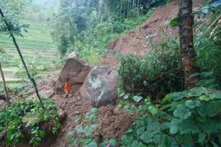 Seorang regu penyelamat dari SAR Bumi Serasi melihat dua   batu besar yang menutup jalan penghubung Dusun Gowono-Dusun Kenongo,   Desa Sepakung, Banyubiru, Kabupaten Semarang, Rabu (13/4/2016) siang.   Dua batu besar tersebut belum bisa dipindahkan, sehinga 200 warga   terisolir