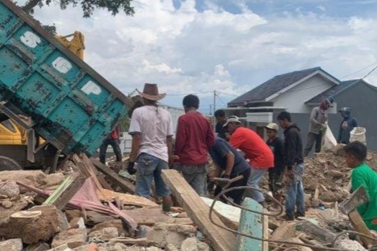Sejumlah pengungsi gempa Cianjur memunguti besi dari sisa puing material bangunan yang rusak akibat gempa bumi.