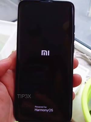 Tangkapan layar video yang menampilkan layar dengan logo Mi dan keterangan dukungan HarmonyOS di smartphone Xiaomi.