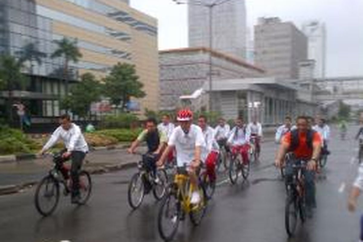 Presiden RI Joko Widodo bersepeda dalam kondisi hujan di Car free day, Minggu (1/1/2015). 