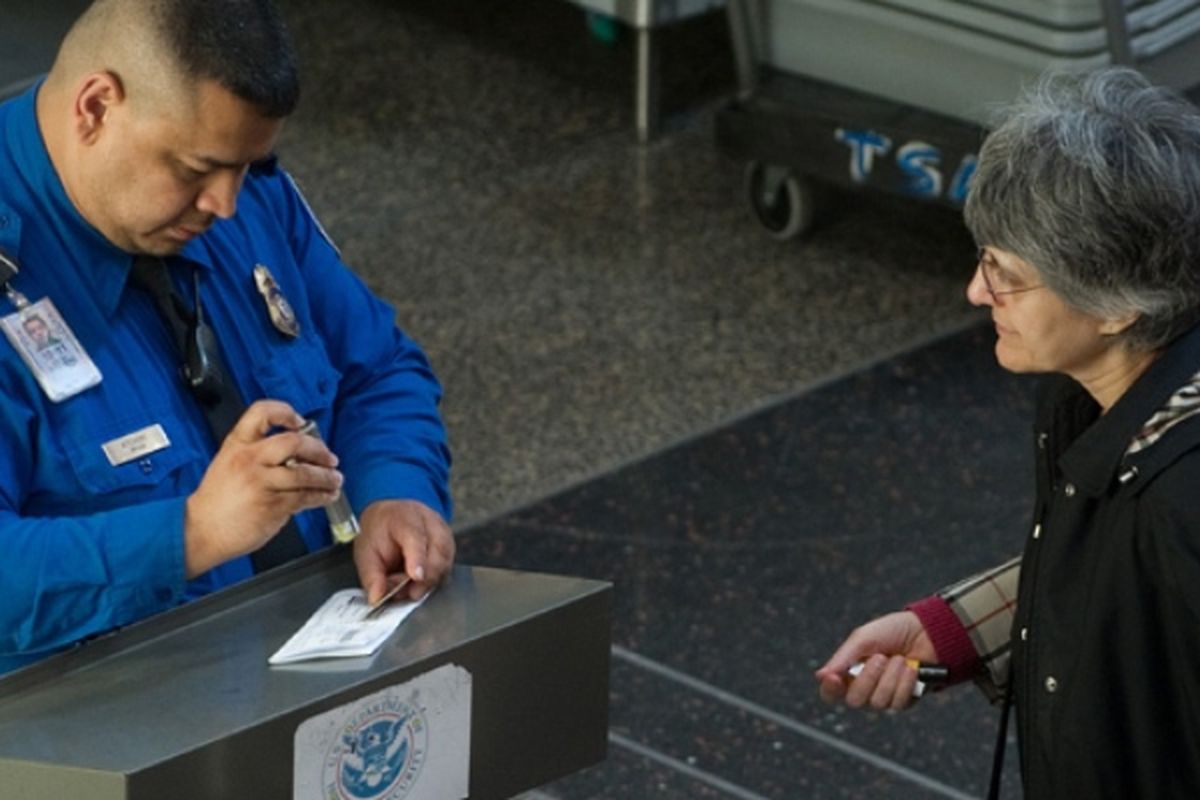 Seorang petugas Badan Keamanan Transportasi (TSA) memeriksa identitas penumpang di boarding pass di bandara nasional Ronald Reagan, Arlington, Virginia.