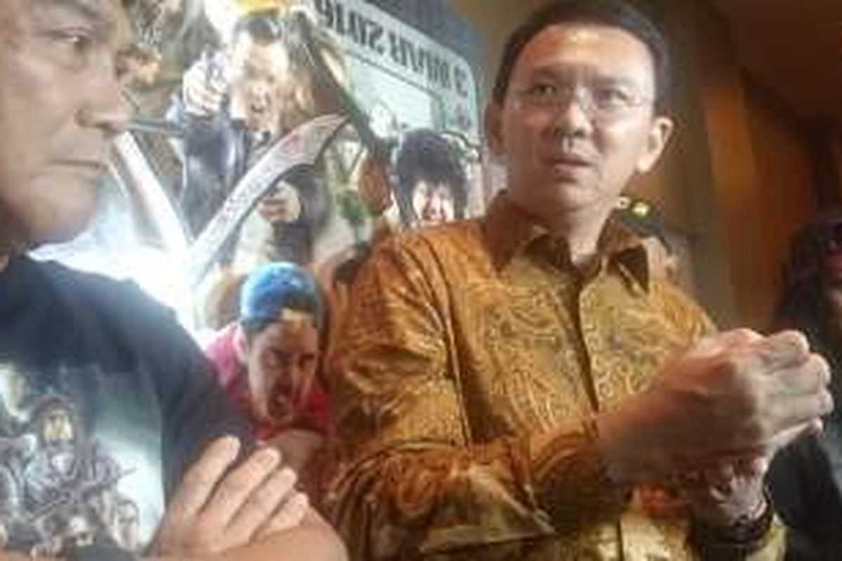 Gubernur DKI Jakarta, Basuki Tjahaja Purnama atau Ahok, bersama Willy Dozan (kiri) dan Candil (kanan), yang main dalam Comic 8: Kasino King Part 2, diwawancara oleh para wartawan usai menonton bareng film itu di Djakarta Theater XXI pada Jumat (18/3/2016) malam.