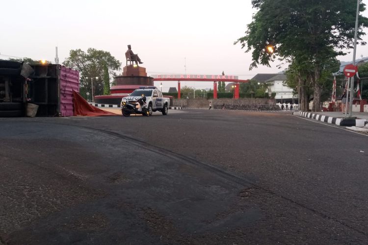 TERGULING—Truk pengangkut belasan ton jagung terguling di depan patung Bung Karno yang berada di depan alun-alun Giri Krida Bakti Wonogiri, Kabupaten Wonogiri, Jawa Tengah, Selasa (29/8/2/2023).