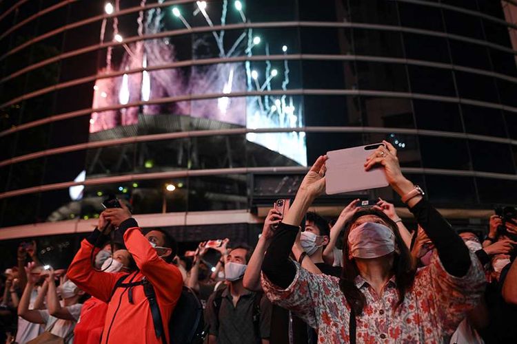 Warga mengambil foto parade kembang api yang menyemarakkan upacara penutupan Olimpiade Tokyo 2020 di Stadion Olimpiade Tokyo, Jepang, Minggu (8/8/2021). Pesta olahraga multicabang tingkat dunia ini resmi berakhir seusai upacara penutupan. Sebanyak 46 cabang olahraga dilombakan dalam gelaran olahraga terbesar se-jagat ini.