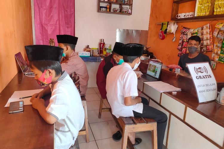 Sejumlah siswa Sekolah Dasar mengikuti pembelajaran daring di Warung Kopi kawasan Pondok Aren Tangerang Selatan, Kamis (30/7/2020)