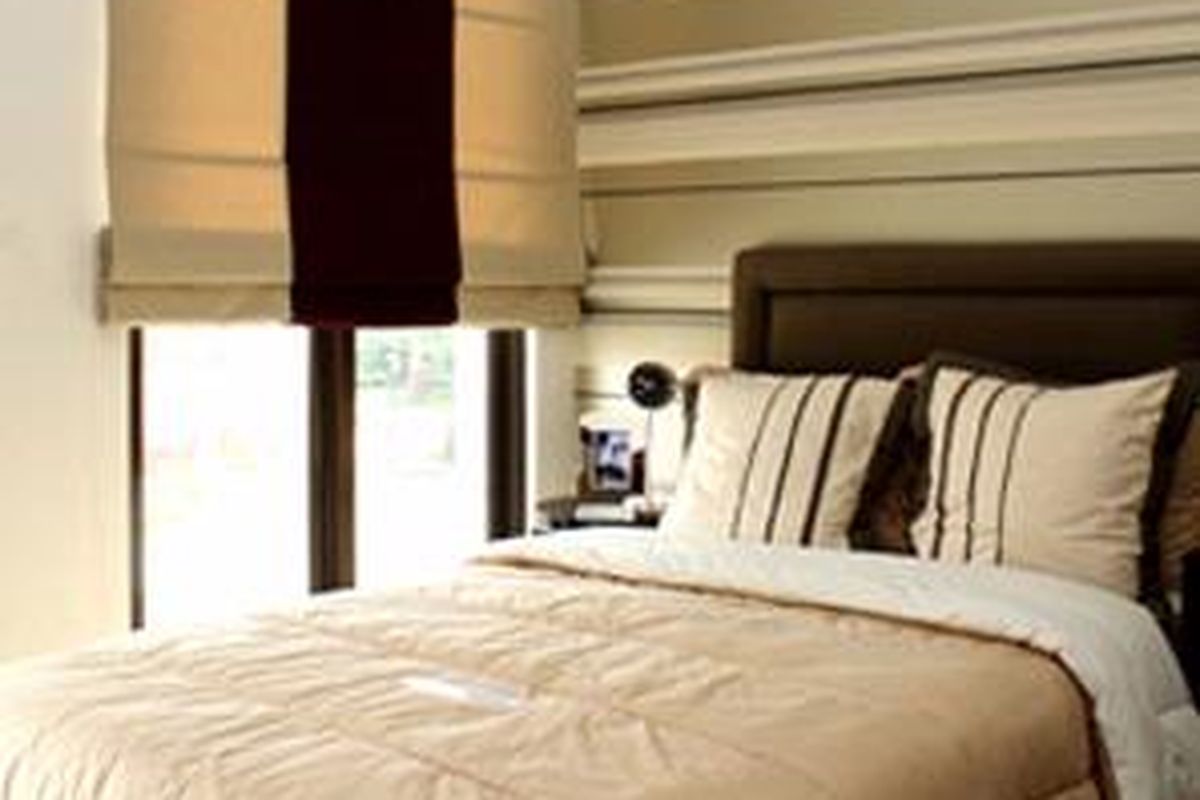 Suasana berbeda hadir di kamar. Wallcover bergaris dipasang pada dinding bagian belakang ranjang. Motifnya seakan menciptakan dinding bergaris-garis.