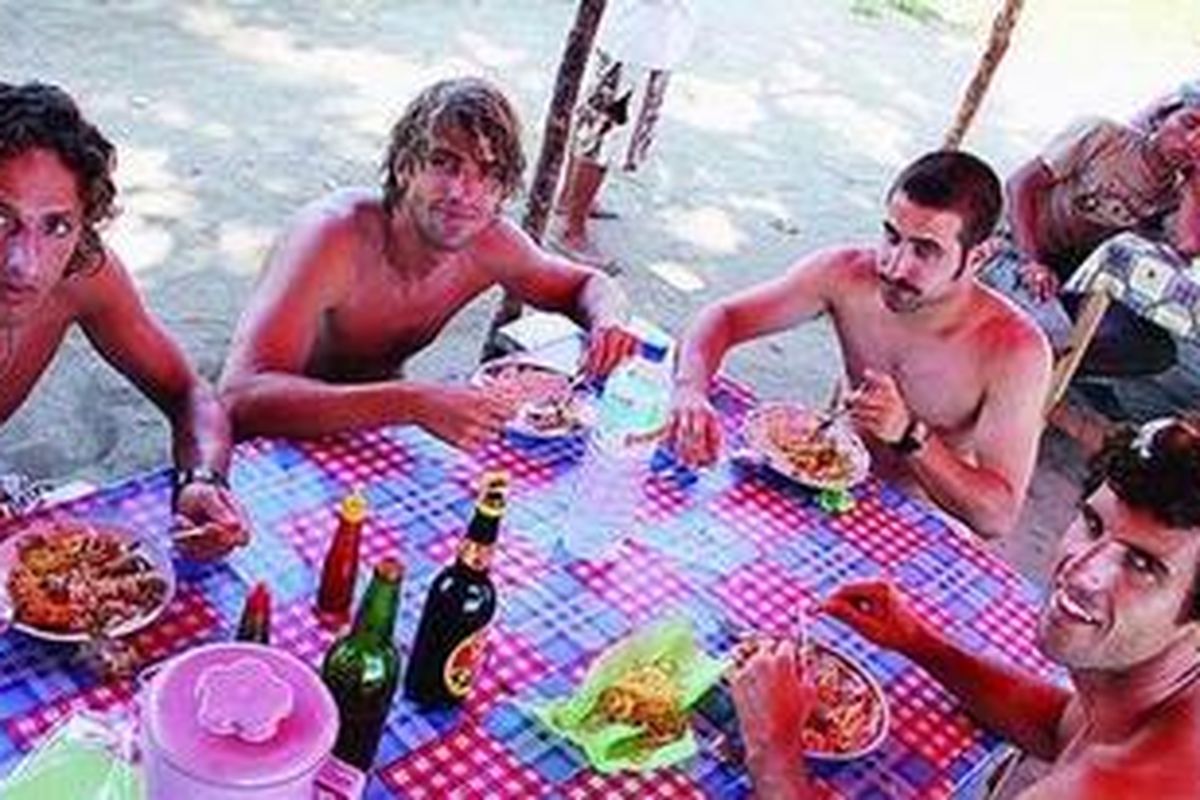 Turis-turis Spanyol menghabiskan waktu untuk surfing (berselancar) hampir satu bulan di pantai Huu, Kabupaten Dompu, Nusa Tenggara Barat. Tampak mereka sedang makan, Jumat (11/6/2010) . 