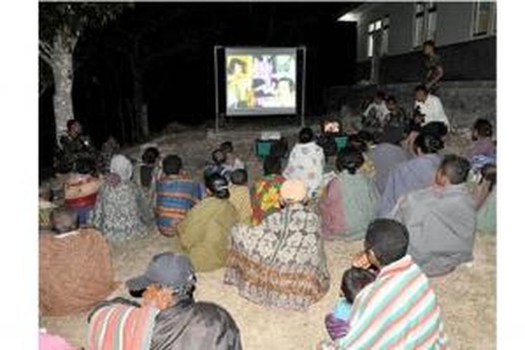 Warga Desa Sunsea, Kecamatan Naibenu, Kabupaten Timor Tengah Utara, menonton film bersama anggota Satuan Tugas Pengamanan Perbatasan RI-Timor Leste, Minggu (27/10/2013). 