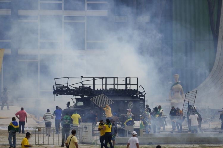 Massa pendukung mantan Presiden Brasil Jair Bolsonaro menyerang kendaraan lapis baja polisi setelah mereka menyerbu Istana Planalto di Brasilia, Brasil, Minggu (8/1/2023). 
