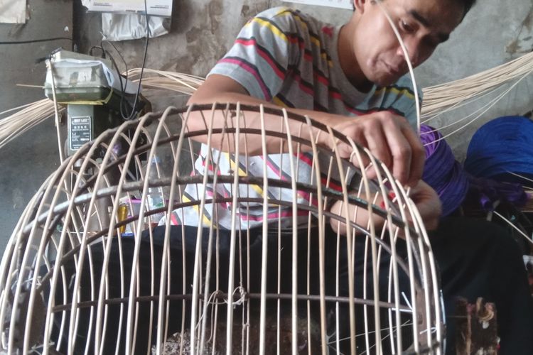 Perajin lampion tengah membuat lampion berbentuk bulat di garasi rumah yang dijadikan tempat produksi lampion, di Kota Bandung, Sabtu (18/1/2025).