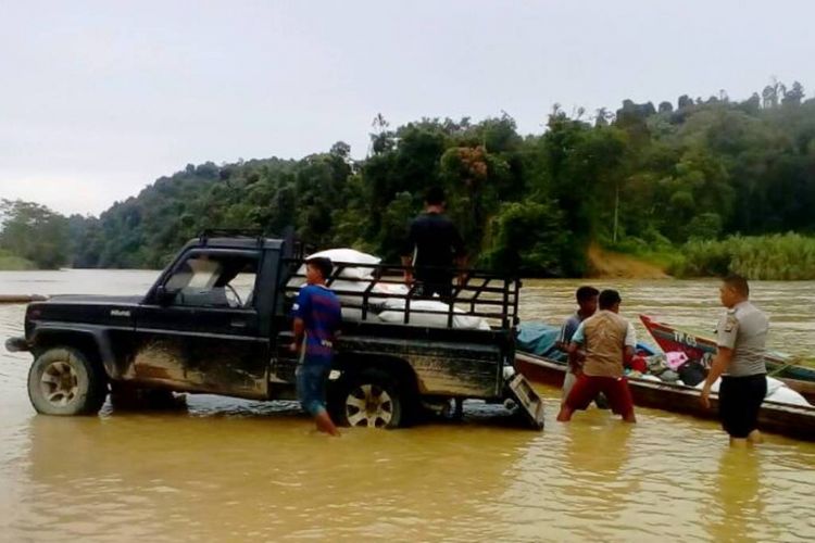 Polisi mengangkut beras dari mobil ke perahu di pinggir Sungai Simpang Jernih, Kecamatan Simpang Jernih, Aceh Timur, Minggu (19/6/2017)