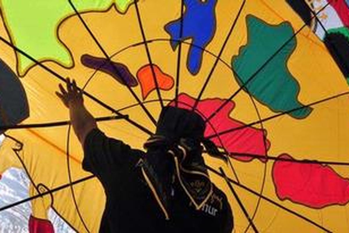 Pemain layang-layang dari Jawa Timur menerbangkan karyanya di Jakarta International Kite Festival 2012 di Pantai Karnaval, Taman Impian Jaya Ancol, Jakarta Utara, Sabtu (30/6/2012). Festival yang bertemakan 