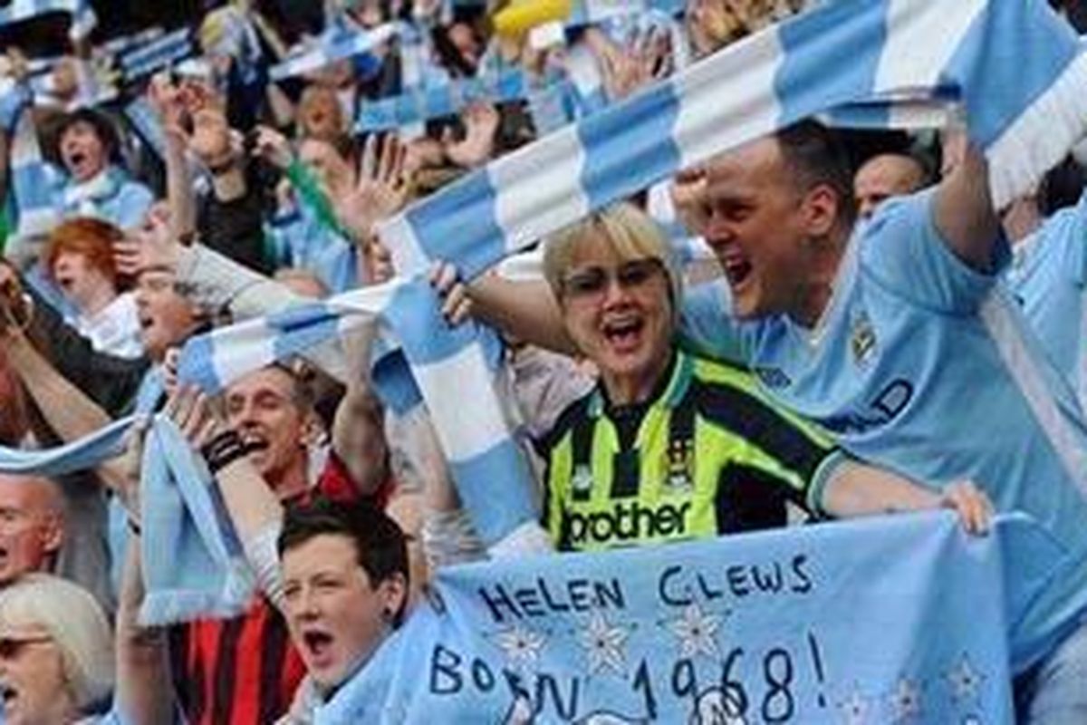 Pendukung Manchester City bersorak menyambut keberhasilan timnya menjuarai Premier League musim ini. 