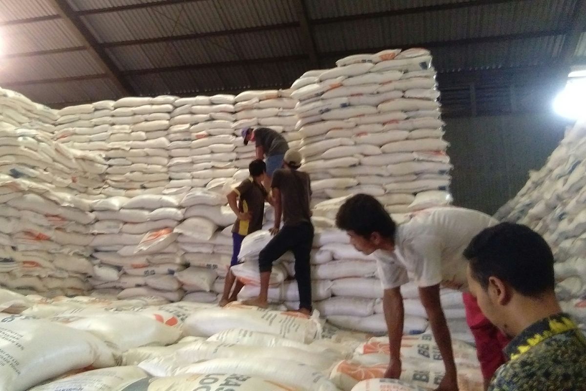 Para pekerja di Gudang Bulog, Kelapa Gading, Jakarta, menata tumpukan beras, Kamis (27/2/2020).