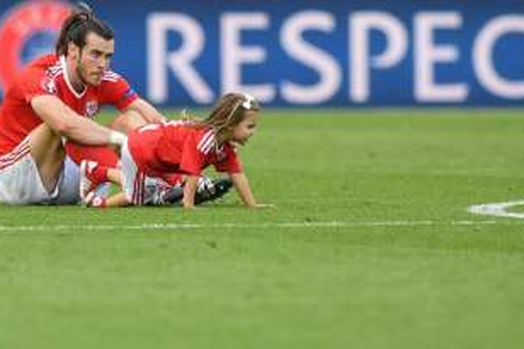 Gareth Bale dan putrinya, Viola Alba, merayakan kemenangan Wales atas Irlandia Utara pada babak 16 besar Piala Eropa di Stade Parc des Princes, Sabtu (25/6/2016).  
